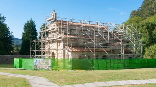 Historic church building restoration with scaffolding and clay tile roof repair