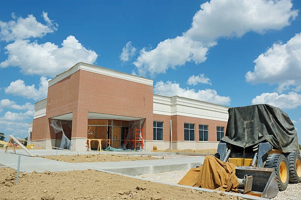 New commercial building construction with brick facade and flat roof structure