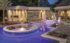 Luxury residential home with quality architectural shingle roofing and illuminated pool area