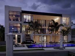 Modern luxury home with flat roof design at twilight with illuminated interior