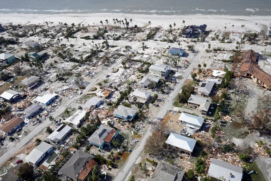 Aerial view of hurricane damage to coastal homes showing widespread roof and property destruction