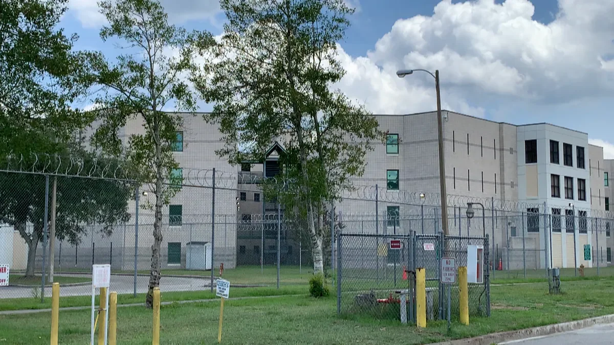 Multi-story commercial building with flat roof and security fencing