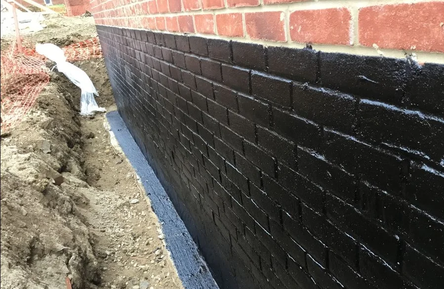Exterior waterproofing applied to a concrete building envelope on a waterfront structure