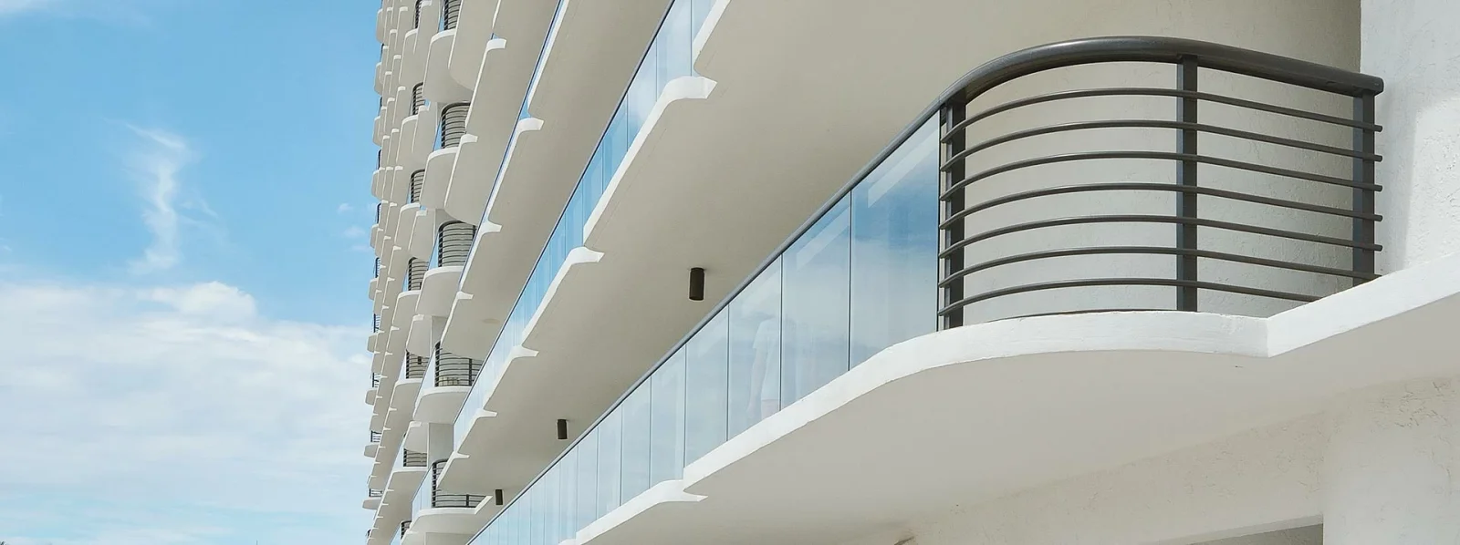 Modern commercial building exterior with curved glass balcony railings